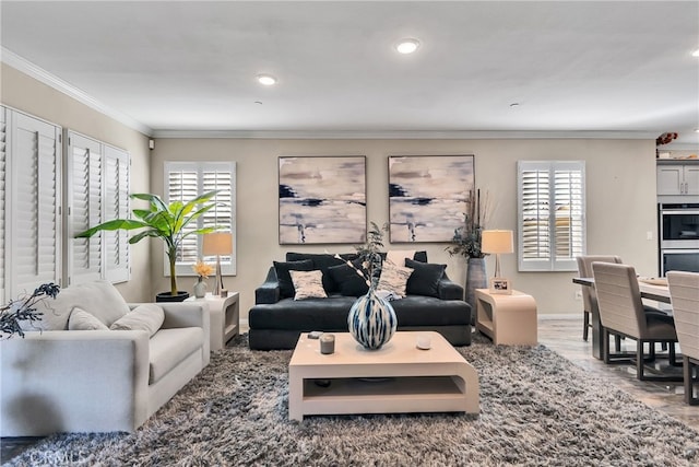 living room featuring a healthy amount of sunlight, ornamental molding, and hardwood / wood-style flooring