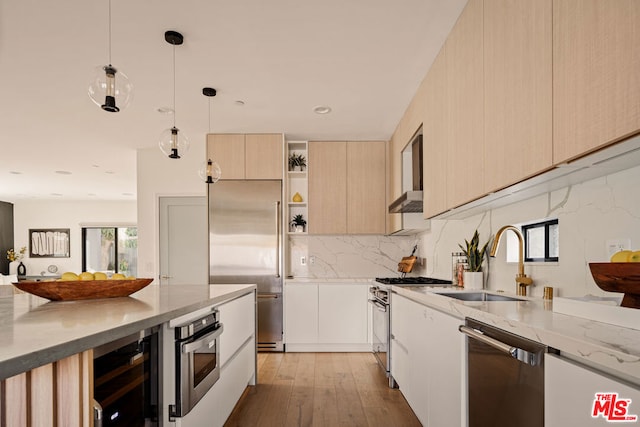 kitchen with wine cooler, pendant lighting, sink, light hardwood / wood-style flooring, and high quality appliances