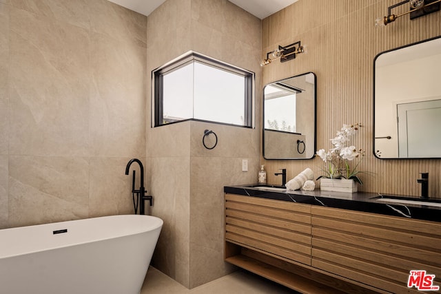 bathroom with tile walls, a tub to relax in, and vanity