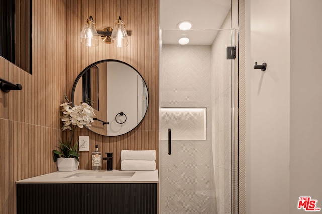 bathroom featuring a shower, wood walls, and vanity