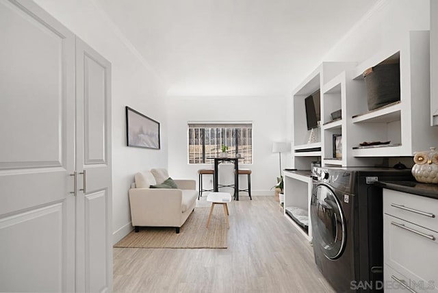 laundry area with light hardwood / wood-style floors, crown molding, and washer / clothes dryer