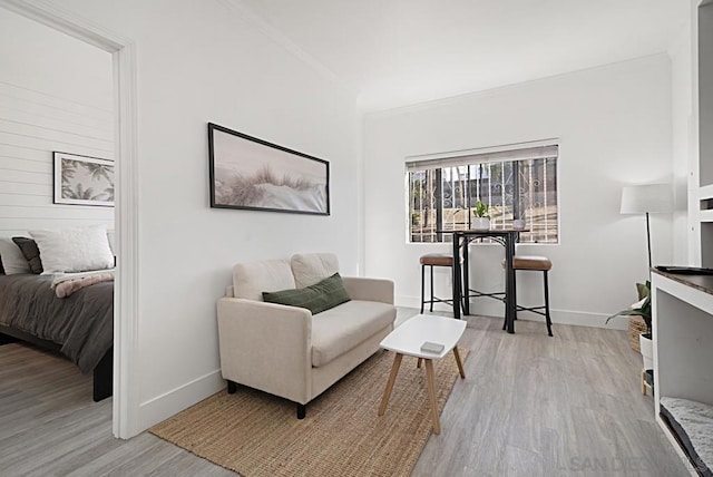 living area featuring ornamental molding and light hardwood / wood-style floors