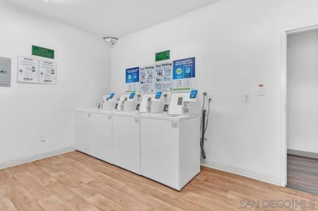 washroom with washer and clothes dryer and light hardwood / wood-style flooring