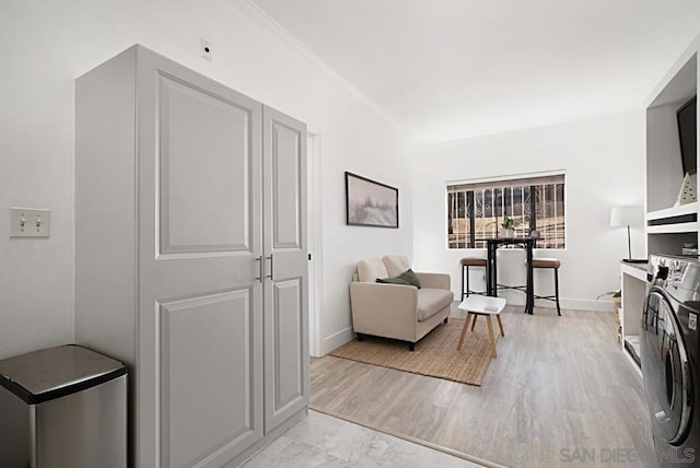 laundry room featuring washer and clothes dryer and light hardwood / wood-style flooring