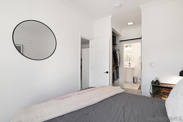 bedroom with connected bathroom and ornamental molding