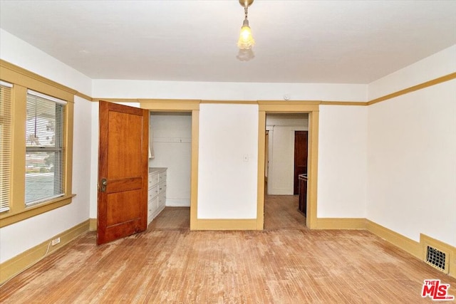 unfurnished bedroom featuring a closet and hardwood / wood-style floors