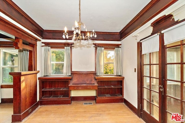 unfurnished room with french doors, light hardwood / wood-style flooring, ornamental molding, and a chandelier