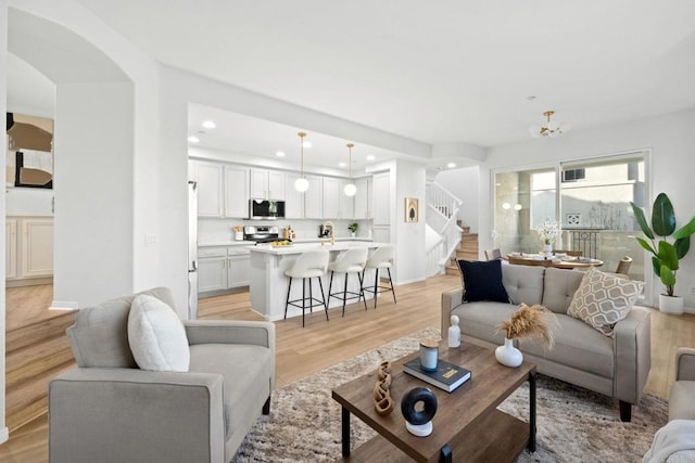 living room featuring an inviting chandelier and light hardwood / wood-style flooring