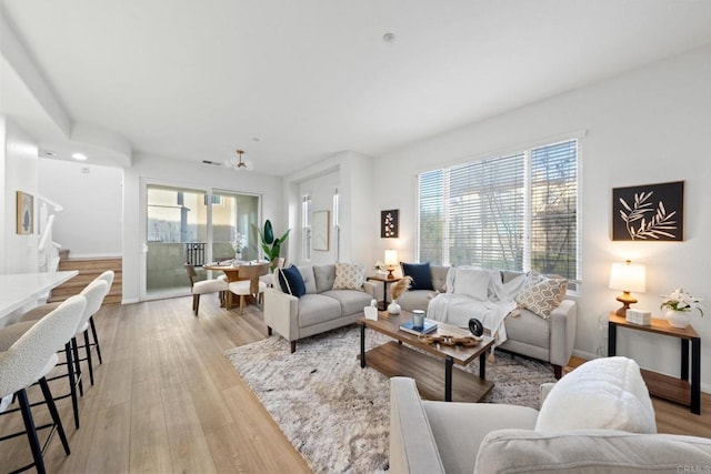 living room with ceiling fan and light hardwood / wood-style flooring