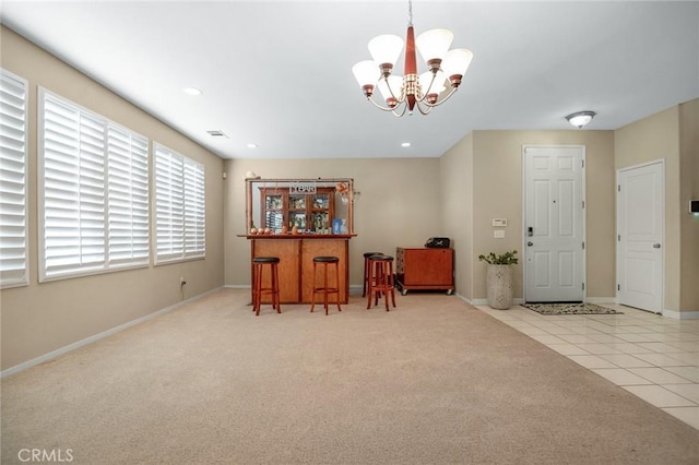 carpeted foyer entrance with a chandelier