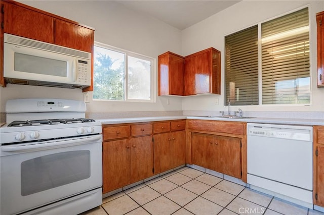 kitchen with sink, white appliances, and light tile patterned floors