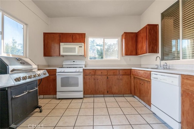 kitchen featuring light tile patterned floors, sink, plenty of natural light, and white appliances