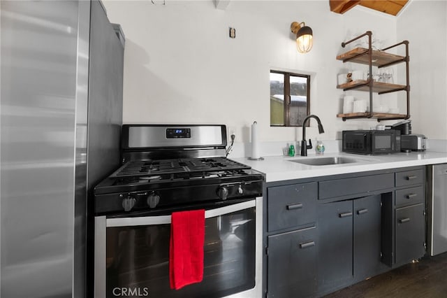 kitchen featuring dark hardwood / wood-style flooring, stainless steel appliances, beamed ceiling, sink, and gray cabinetry