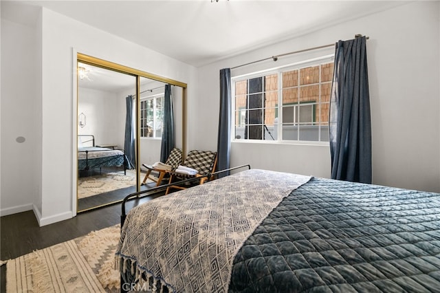 bedroom with dark hardwood / wood-style floors and a closet