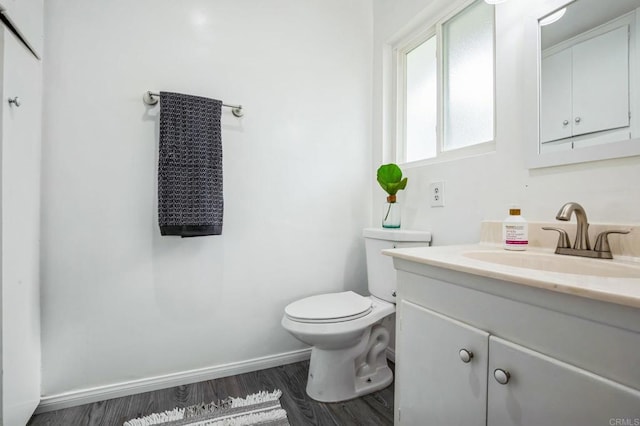 bathroom featuring toilet, hardwood / wood-style flooring, and vanity