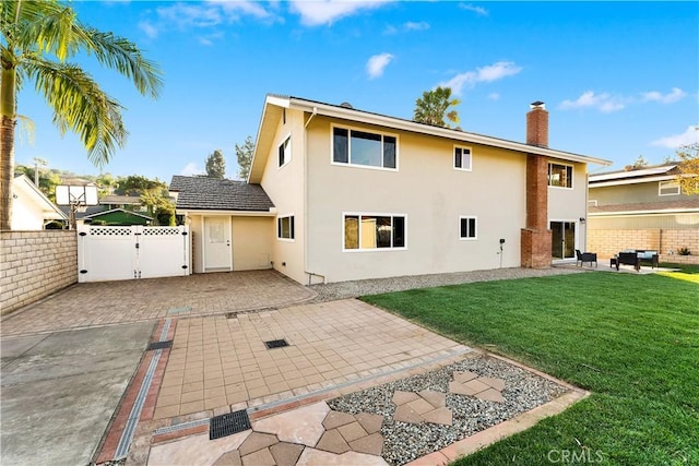 rear view of property featuring a lawn and a patio