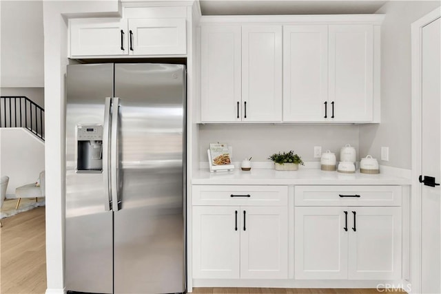 kitchen featuring white cabinets, light wood-type flooring, and stainless steel fridge with ice dispenser