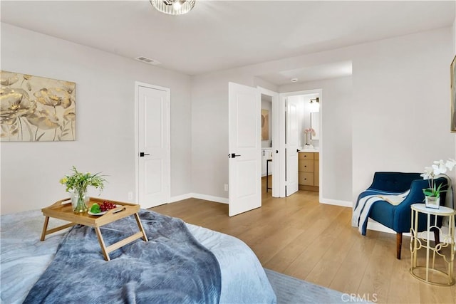 bedroom with hardwood / wood-style floors and ensuite bathroom