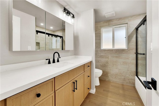 bathroom with toilet, walk in shower, hardwood / wood-style flooring, and vanity