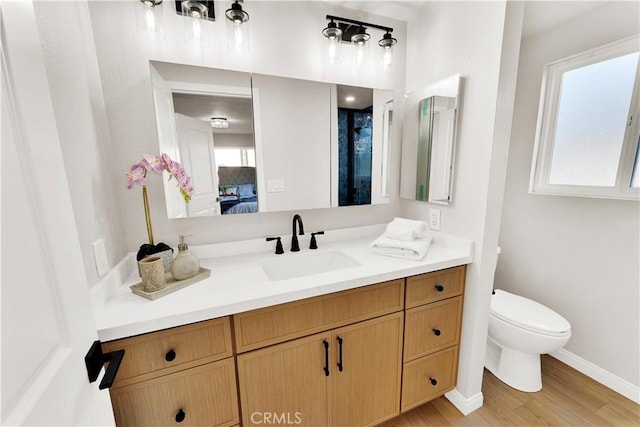 bathroom featuring hardwood / wood-style flooring, toilet, and vanity