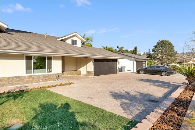 single story home featuring a garage and a front yard