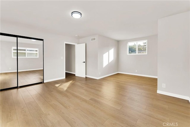 unfurnished bedroom featuring light wood-type flooring and a closet