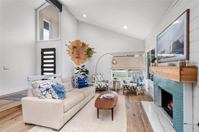 living room with high vaulted ceiling and light wood-type flooring