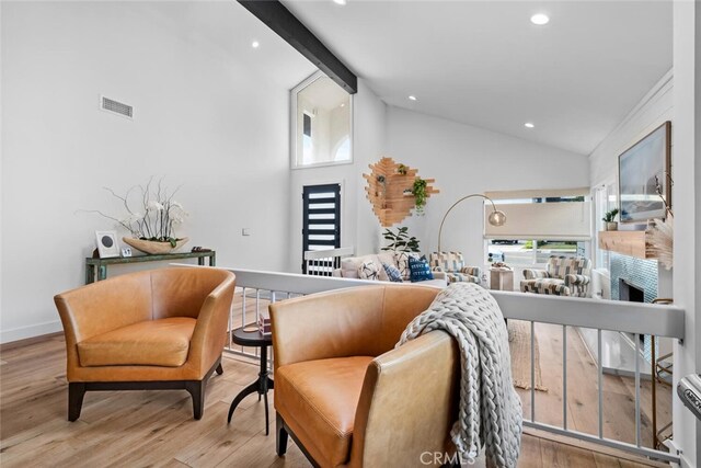 interior space featuring light wood-type flooring, high vaulted ceiling, and beamed ceiling