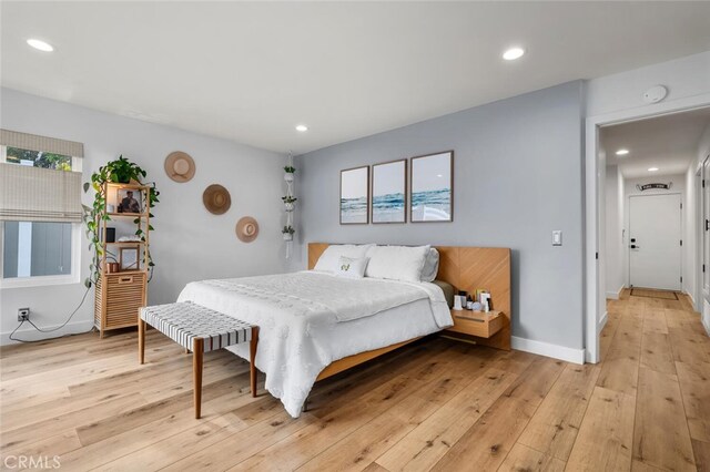 bedroom with multiple windows and light wood-type flooring