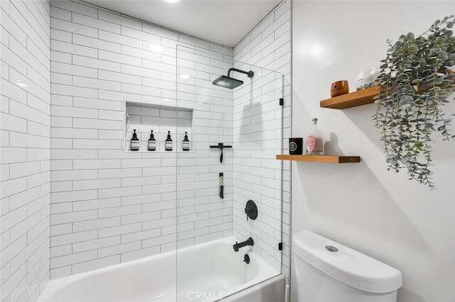 bathroom with toilet and tiled shower / bath