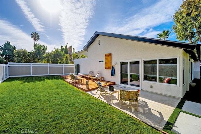 back of property with a wooden deck, a yard, and a patio area