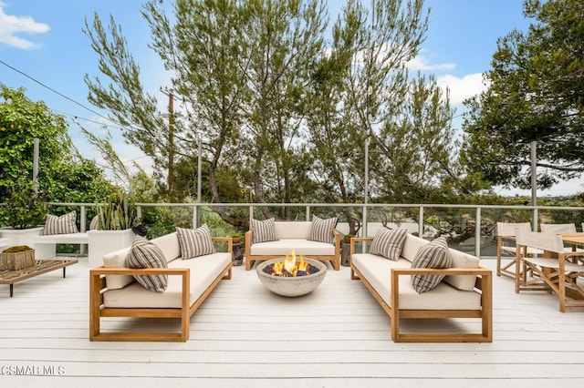 wooden deck with an outdoor living space with a fire pit