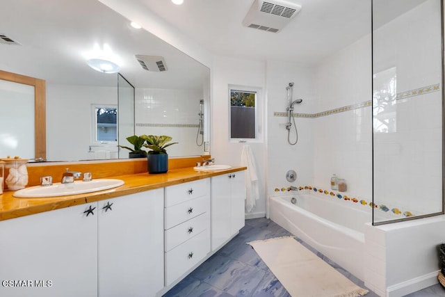 bathroom featuring vanity, tiled shower / bath combo, and plenty of natural light