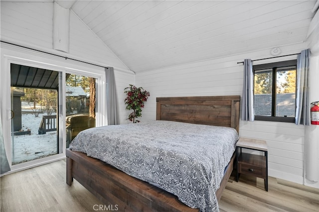 bedroom with access to outside, wooden walls, and multiple windows