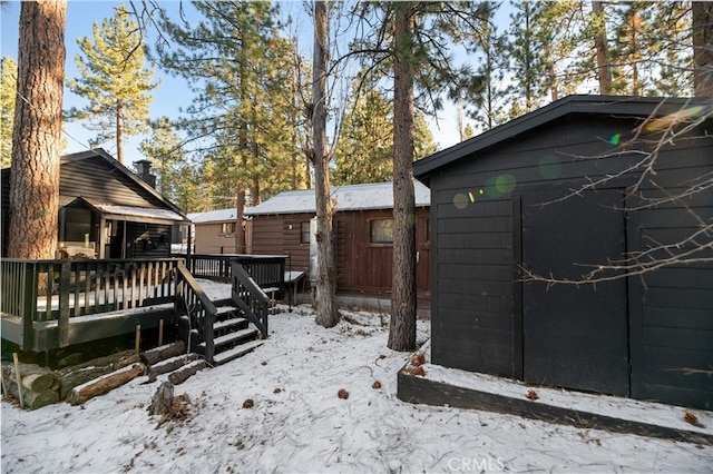 snowy yard featuring a wooden deck