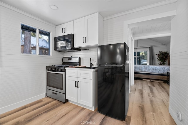 kitchen featuring black appliances, white cabinets, light wood-type flooring, and backsplash