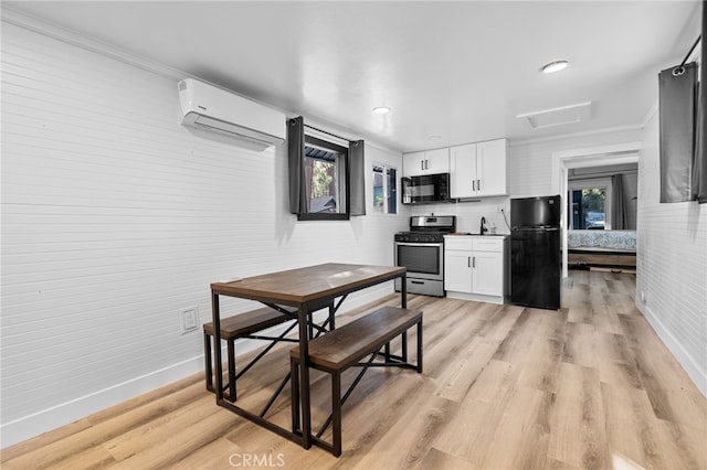 kitchen with black appliances, white cabinets, a wealth of natural light, and a wall mounted air conditioner