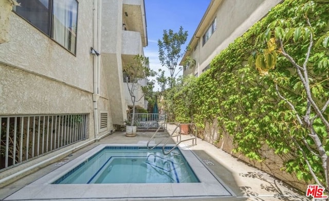 view of swimming pool featuring a patio area and a community hot tub