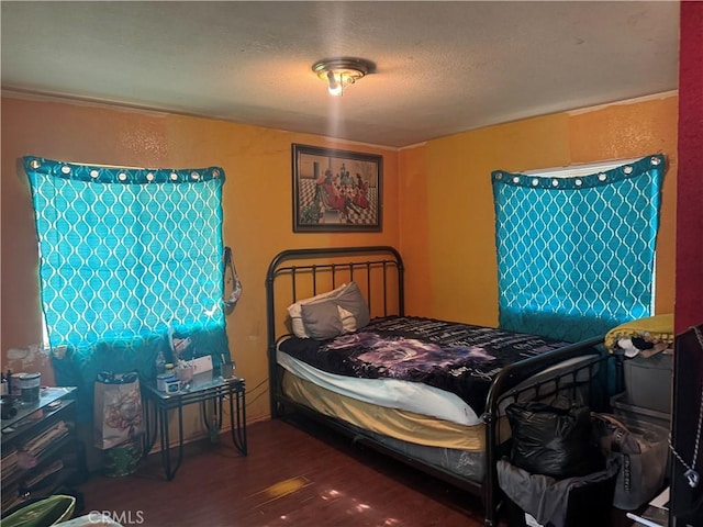 bedroom with a textured ceiling and dark hardwood / wood-style flooring