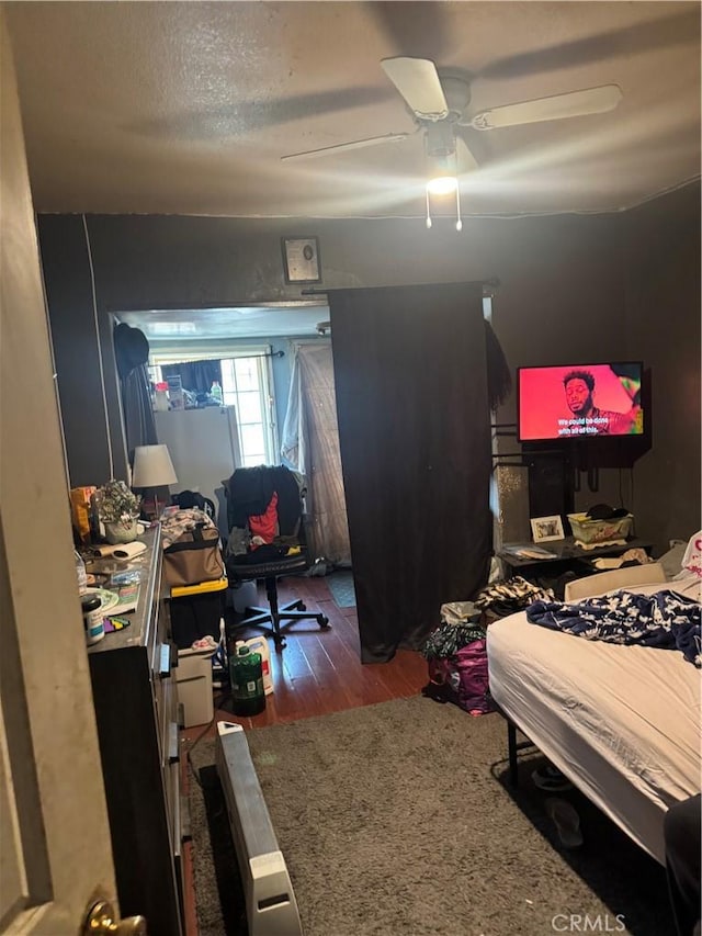 bedroom with ceiling fan, dark hardwood / wood-style floors, and a textured ceiling