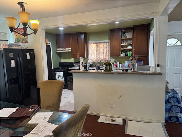 kitchen featuring decorative light fixtures, light stone counters, a notable chandelier, black appliances, and dark brown cabinetry