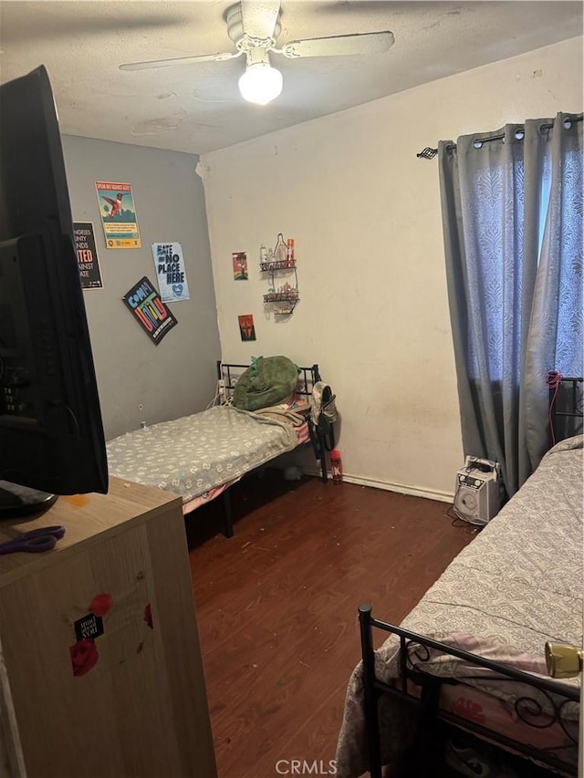 bedroom with ceiling fan and dark hardwood / wood-style floors