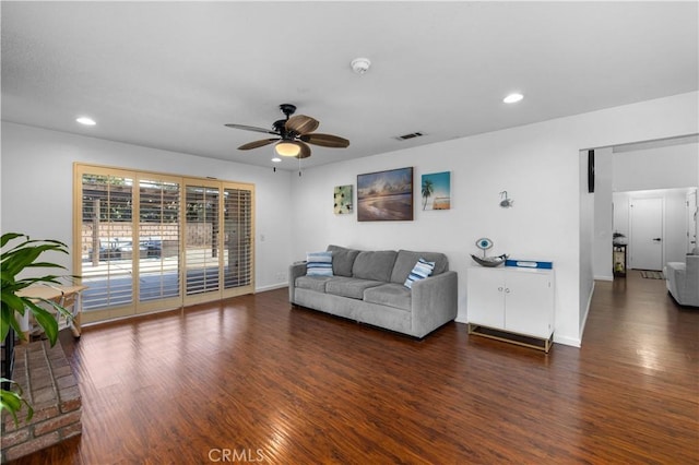 living room with ceiling fan and dark hardwood / wood-style flooring