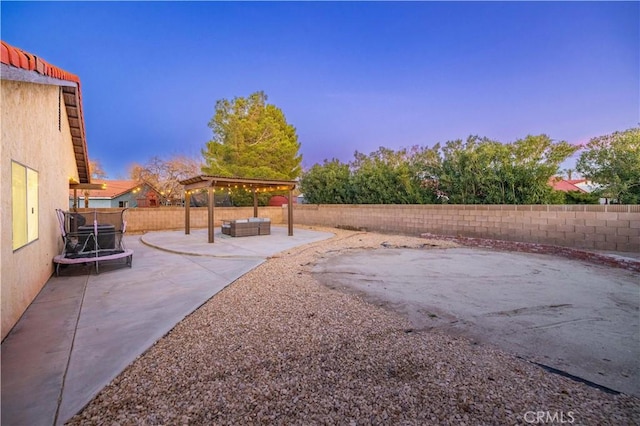 yard at dusk featuring an outdoor living space and a patio