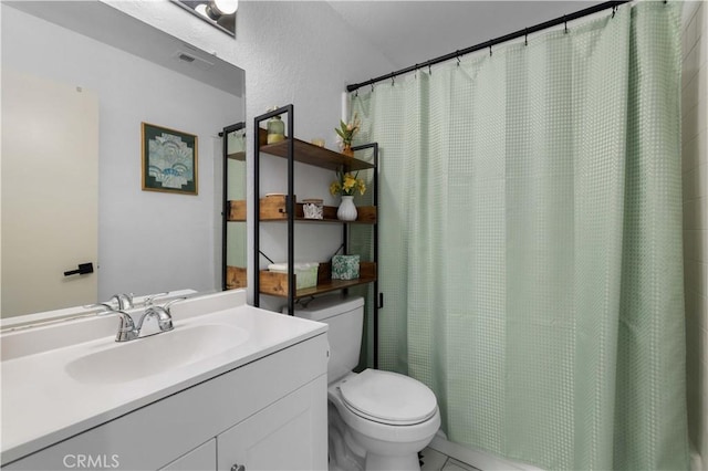 bathroom featuring toilet, vanity, a shower with curtain, and tile patterned flooring