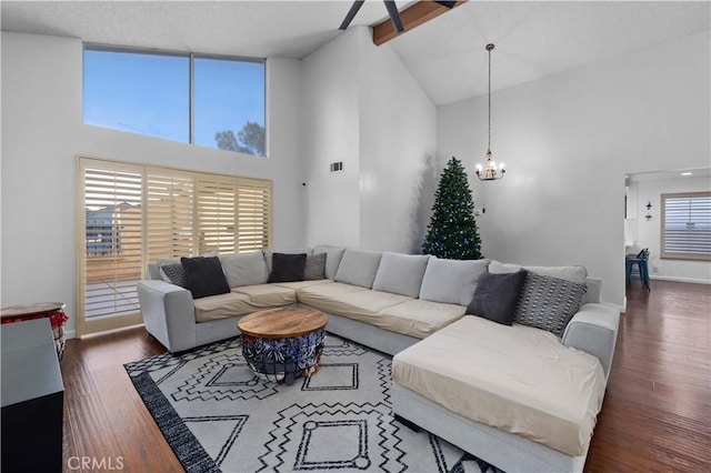 living room with high vaulted ceiling, dark hardwood / wood-style flooring, beam ceiling, and a chandelier