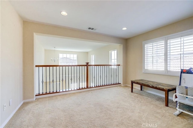 living area featuring light colored carpet and an inviting chandelier