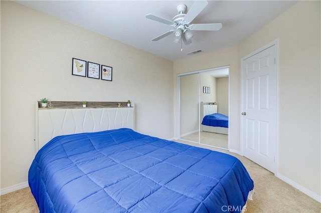 bedroom with ceiling fan, a closet, and light carpet