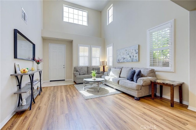 living room featuring light hardwood / wood-style floors and a high ceiling