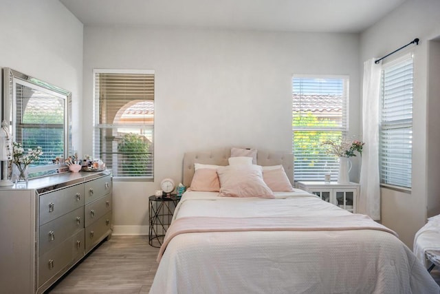 bedroom with light wood-type flooring and multiple windows